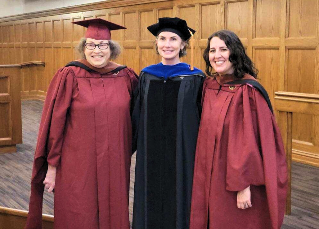 Photo of graduates and faculty in graduation regalia