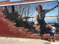 Artist MIchael Rosato, a 1983 graduate of Florida State University, applies protective coating to his mural of abolitionist Harriet Tubman in Cambridge, Maryland. (Photo: Special to the Democrat)